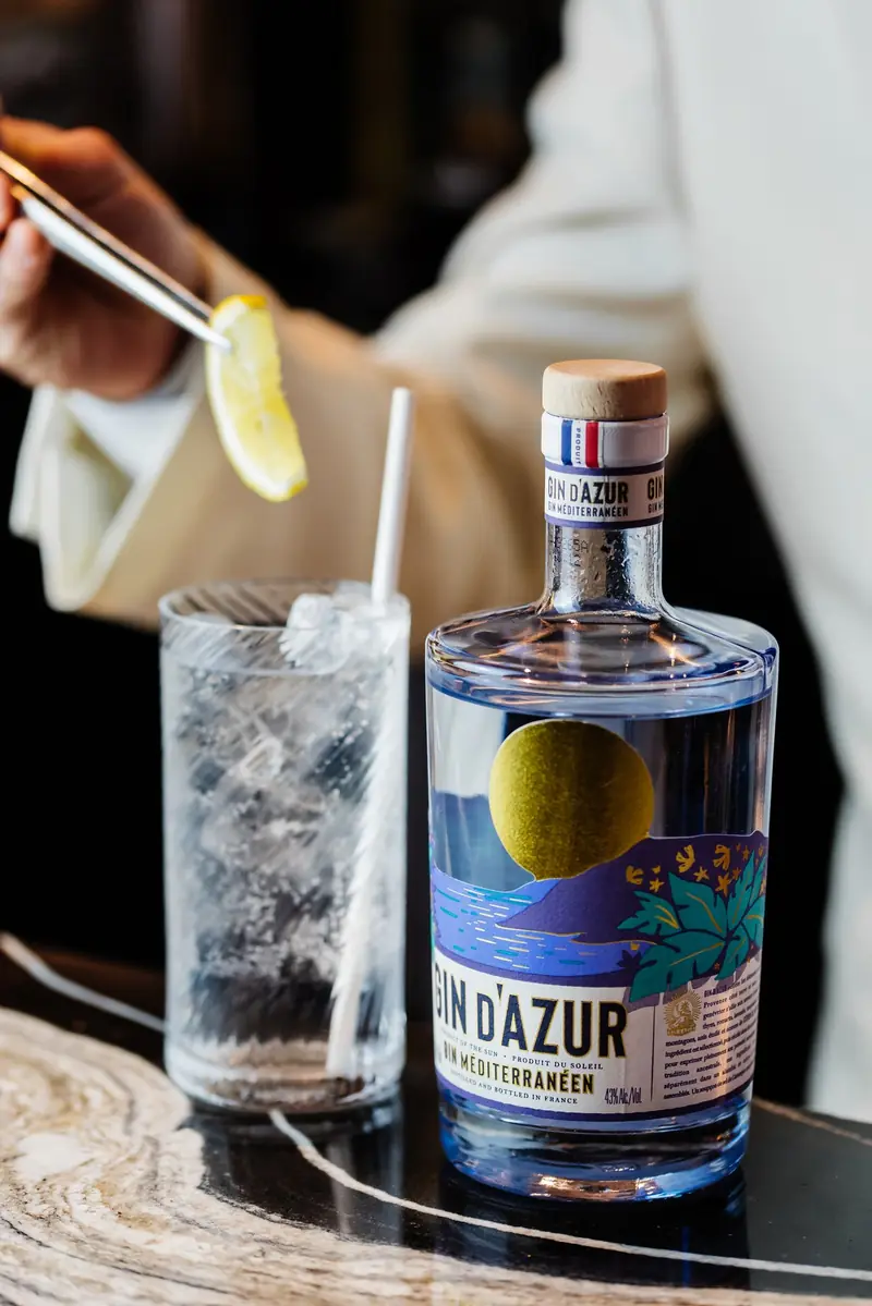 A bartender garnishing a Gin d'Azur and tonic
