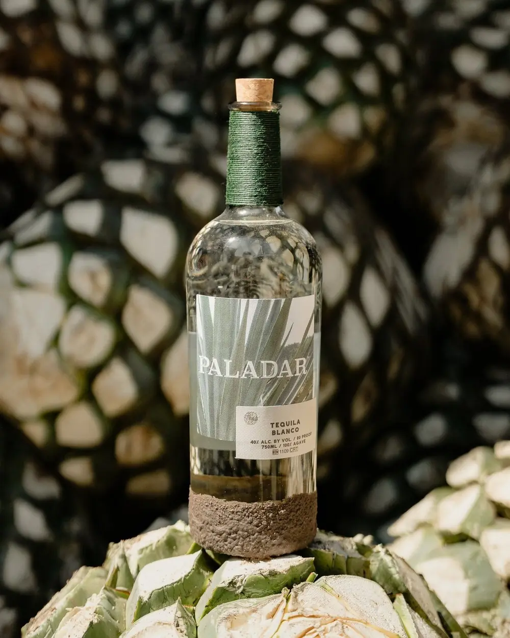 A bottle of Paladar Tequila among harvested agave hearts